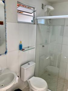 a bathroom with a toilet and a shower and a sink at Villas da Jagua in Jaguaruna