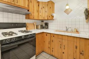 eine Küche mit Holzschränken, einem Herd und einer Spüle in der Unterkunft Cozy summit #2222 in Big Bear Lake