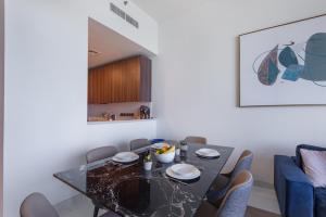 a dining room with a black table and chairs at Maison Privee - Chic Coastal Escape with Open Sea Vws on Palm Entry in Dubai +20 photos