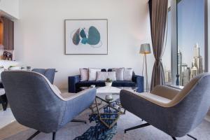 a living room with two chairs and a couch at Maison Privee - Chic Coastal Escape with Open Sea Vws on Palm Entry in Dubai