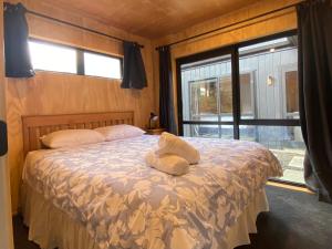 a bedroom with a bed with two towels on it at Brand New 4BR Alpine Home Near Turoa Ski Field in Ohakune