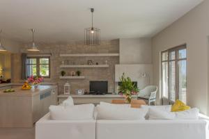 a living room with a white couch and a kitchen at Villa Bilio in Kissamos
