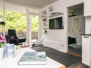 a living room with a table and a tv at 4 person holiday home in Ringkøbing in Ringkøbing