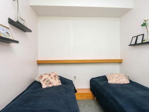 a bedroom with two beds and a wall with shelves at 4 person holiday home in Ringkøbing in Ringkøbing