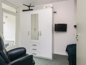 a living room with a white cabinet and a chair at 4 person holiday home in Ringkøbing in Ringkøbing
