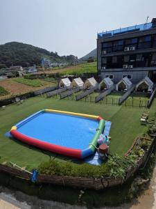 a large inflatable pool in a field with tents at Namhae Dangdangi Dog Pension Blue in Namhae