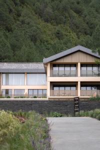 a building in front of a mountain with trees at Lugu Lake Manchen Vacation Homestay in Ninglang +23 photos