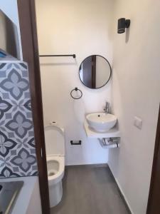 a bathroom with a toilet and a sink and a mirror at Hotel Boutique Luz de Luna in San Blas