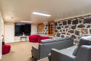 a living room with couches and a stone wall at Road Creek Inn in Loa