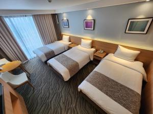 Postel nebo postele na pokoji v ubytování Seogwipo JS Hotel