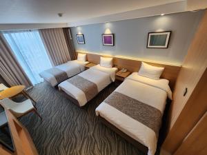 Postel nebo postele na pokoji v ubytování Seogwipo JS Hotel