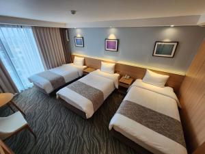 Postel nebo postele na pokoji v ubytování Seogwipo JS Hotel