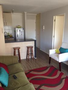 a living room with a couch and a kitchen at Depto Puertas del Mar La Serena in La Serena