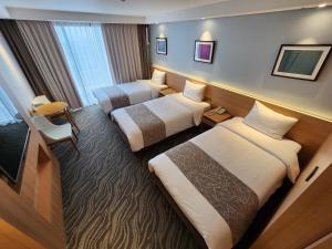 Postel nebo postele na pokoji v ubytování Seogwipo JS Hotel