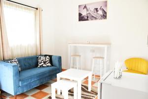 a living room with a blue couch and a table at Lion Hill Place in Nakuru