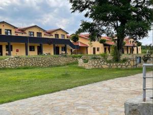 a building with a tree and a stone wall at QUEEN MARIA Apartments in Demir Kapija