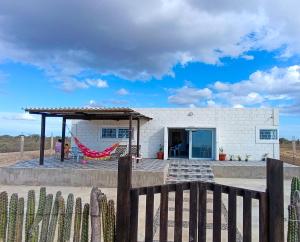 a house with a hammock in front of it at Refugio, Casa de la Playa in Manaure
