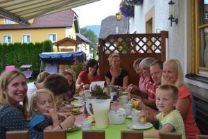 a group of people sitting at a table eating at Biobauernhof Tonimörtl in Mariapfarr
