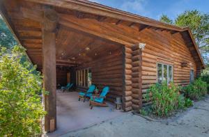 a log cabin with blue chairs on a patio at Oakwood Lodge in Nipomo