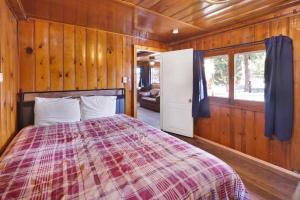 Un dormitorio con una cama en una habitación de madera. en Lakeview #104, en Big Bear Lake 17 fotos más