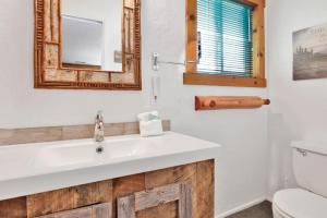 een badkamer met een wastafel, een toilet en een spiegel bij Lakeview getaway #2120 in Big Bear Lake