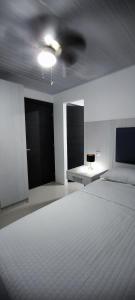 ein Schlafzimmer mit einem weißen Bett und einer Decke in der Unterkunft Apartamento en el centro de Matagalpa in Matagalpa