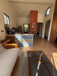Una sala de estar con un sofá y una cocina. en The Weiss House - Mountain, Pool and Rest, en Tepoztlán