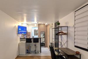 a dining room with a table and a television on a wall at Luxury studio Évry - Ris, 25 min to Paris in Ris-Orangis