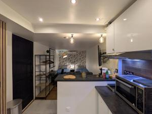 a kitchen with a counter and a living room at Luxury studio Évry - Ris, 25 min to Paris in Ris-Orangis