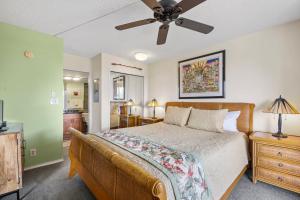 ワイレアにあるCentral 1 bedroom gorgeous beaches MBG405のベッドと天井扇風機のある寝室