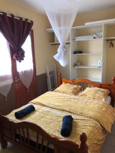 a bedroom with a bed with a yellow comforter at Hauteur de Fort de France in Fort-de-France