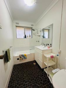 a bathroom with a white tub and a sink at Tranquil Retreat in Chatswood in Sydney