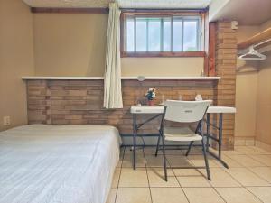a bedroom with a bed and a table and chairs at Wendy in the prairie in Saskatoon