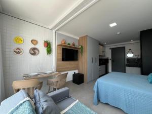 a bedroom with a blue bed and a kitchen at Espaço e conforto em frente ao mar in João Pessoa