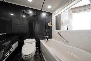 a black and white bathroom with a toilet and a tub at Tokyu Stay Kamata - Tokyo Haneda in Tokyo