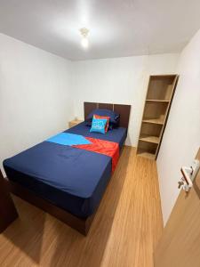 a bedroom with a bed and a book shelf at Ambon Residence Syariah in Ambon
