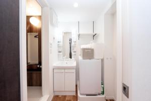 a white bathroom with a sink and a mirror at 銀座線徒歩9分 松が谷アパート in Tokyo +101 photos