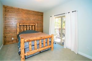 een slaapkamer met een bed met een houten muur bij Alpine chalet #1840 in Big Bear Lake