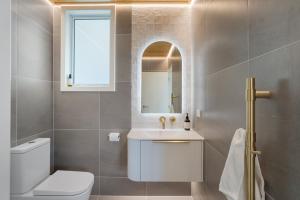 a bathroom with a toilet and a sink and a mirror at Luxury Lakeside Landing in Queenstown