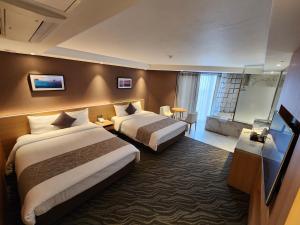 Postel nebo postele na pokoji v ubytování Seogwipo JS Hotel + 37 fotografií
