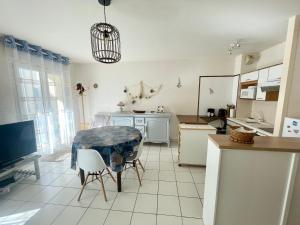 a kitchen with a table and chairs and a tv at Appartement Cozy, 4 Pers, Centre-Ville, Proche Plage et Commerces - FR-1-92-877 in Les Sables-dʼOlonne