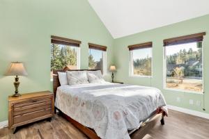 a bedroom with green walls and a bed and windows at Fawnskin Chalet#1826 in Fawnskin