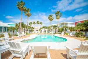 a swimming pool with white chairs and a white table and chairs at Casa Las Palmas - Pet Friendly! Boardwalk to the Beach! in Mustang Beach