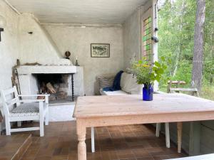 a porch with a wooden table and a fireplace at 4 star holiday home in DEGEBERGA in Degeberga
