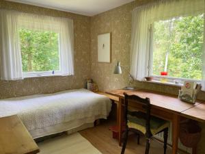 a bedroom with a desk and a bed and two windows at 4 star holiday home in DEGEBERGA in Degeberga