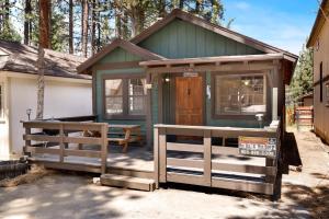 a green tiny house with a porch and a fence at Brown bears cabin #1091 in Big Bear Lake