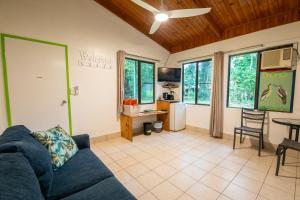 a living room with a blue couch and a kitchen at Daintree Siesta in Daintree