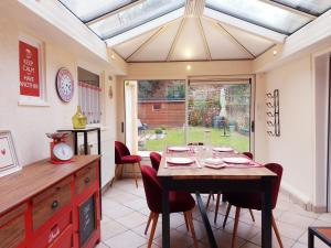una cucina con tavolo con sedie e soffitto in vetro di Maison avec jardin à Châteaudun, près de Paris - FR-1-581-149 a Châteaudun