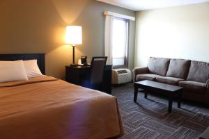 une chambre d'hôtel avec un lit et un canapé dans l'établissement Sunlac Inn Devils Lake, à Devils Lake