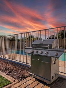 a grill sitting next to a fence next to the water at Kimberly Surprise in Surprise